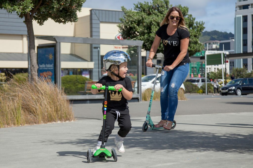 A mum and her child have fun together on their scooters